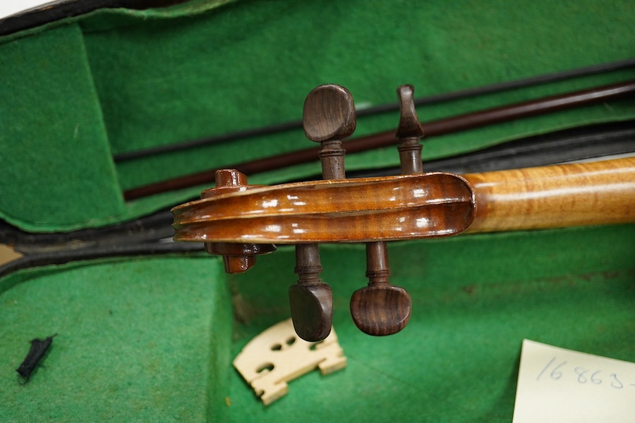 Four cased violins; an early 20th century violin, body 36cm, fitted with a microphone pick up taking a quarter inch jack plug, an early 20th century half size violin, body 32cm, and two student violins. Condition - poor